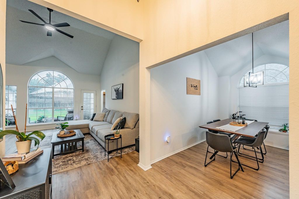 Dining room featuring light wood-style flooring, high vaulted ceiling, and a ceiling fan