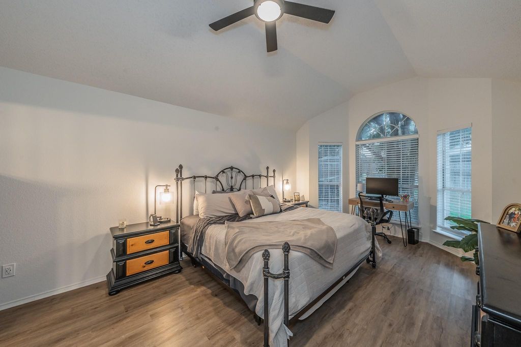 Bedroom with lofted ceiling, dark wood-style flooring, a desk, and ceiling fan