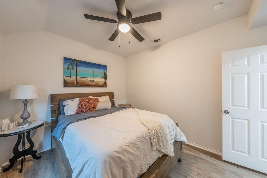 Bedroom with wood finished floors, ceiling fan, and lofted ceiling