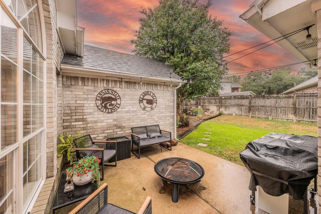 Fenced backyard with a patio and an outdoor living space with a fire pit