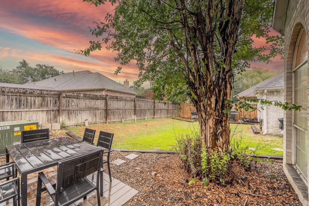 Yard at dusk with a fenced backyard and outdoor dining space