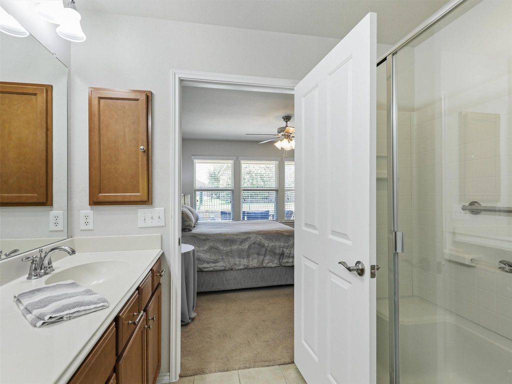 Bathroom featuring vanity, a shower stall, ensuite bath, and light tile patterned floors