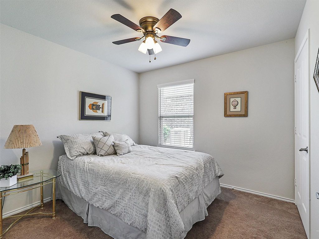 Bedroom with dark carpet and a ceiling fan