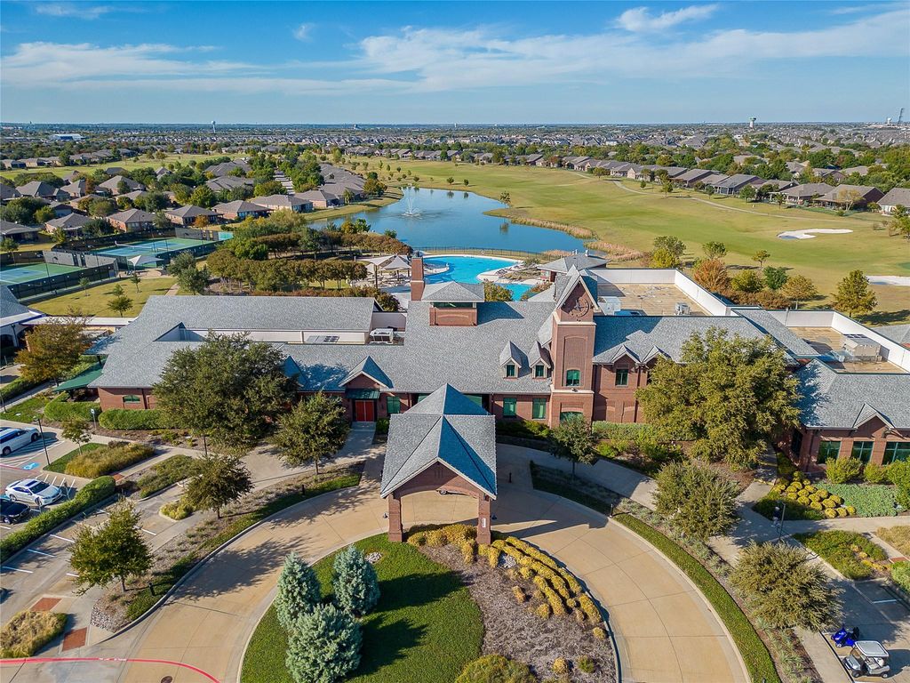Aerial view of residential area featuring a nearby body of water and a golf course