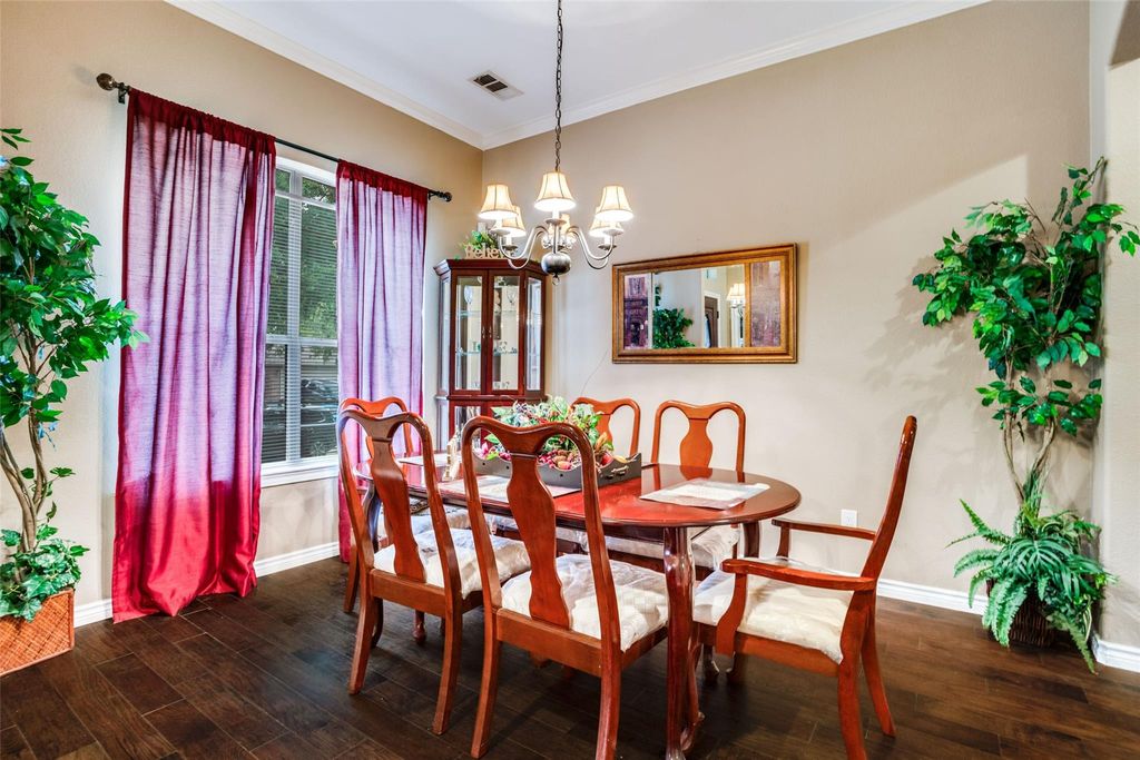 Dining room featuring ornamental molding, a chandelier, and dark wood finished floors