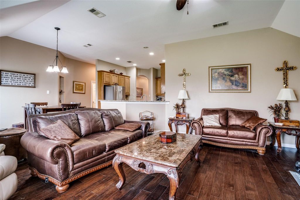 Living area featuring dark wood-type flooring, vaulted ceiling, recessed lighting, a chandelier, and ceiling fan