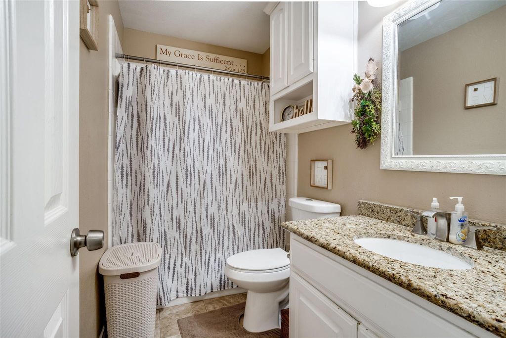 Bathroom featuring vanity, curtained shower, and light tile patterned floors