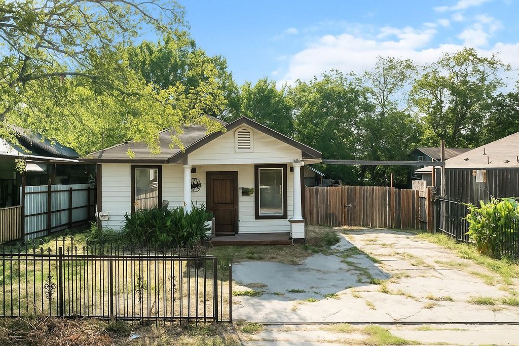 Bungalow-style home featuring a fenced front yard and covered porch