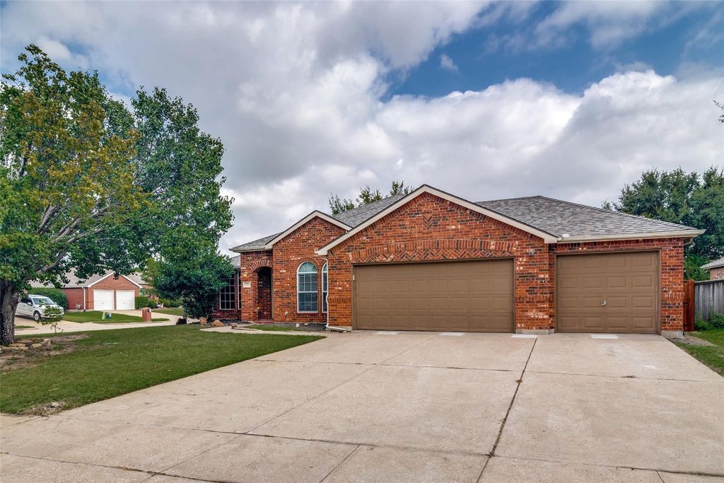 View of front of house with roof with shingles, brick siding, and driveway