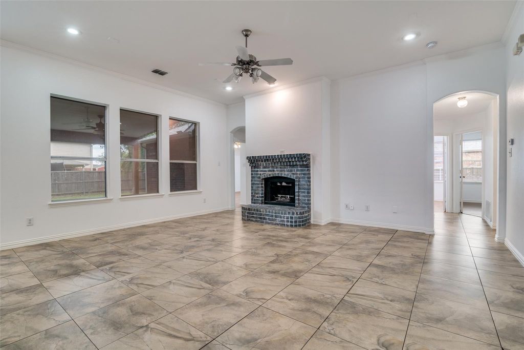 living room with arched walkways, a ceiling fan, a brick fireplace, and recessed lighting