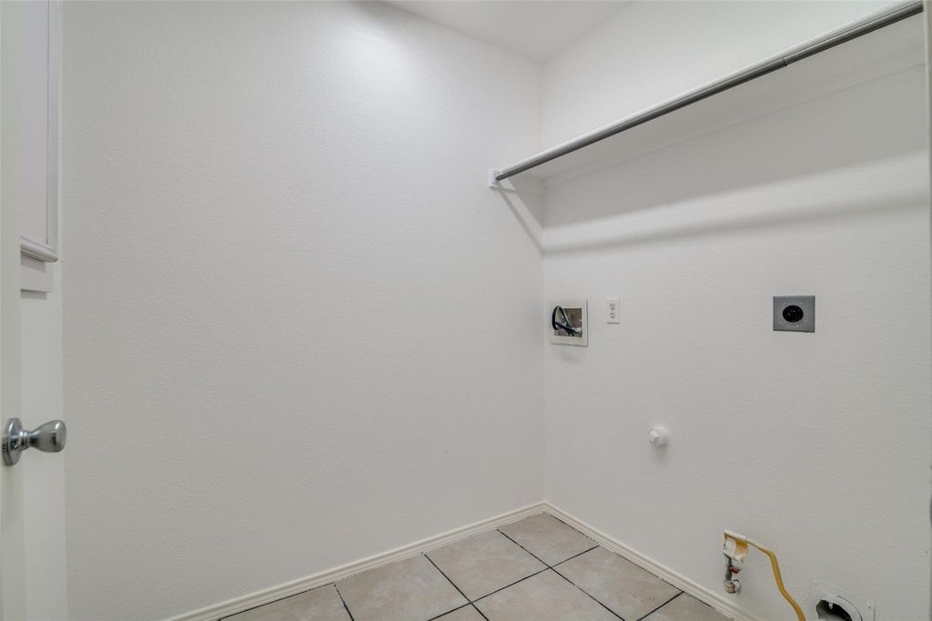 Laundry room  with hookup for a gas dryer, light tile patterned flooring, washer hookup, and electric dryer hookup
