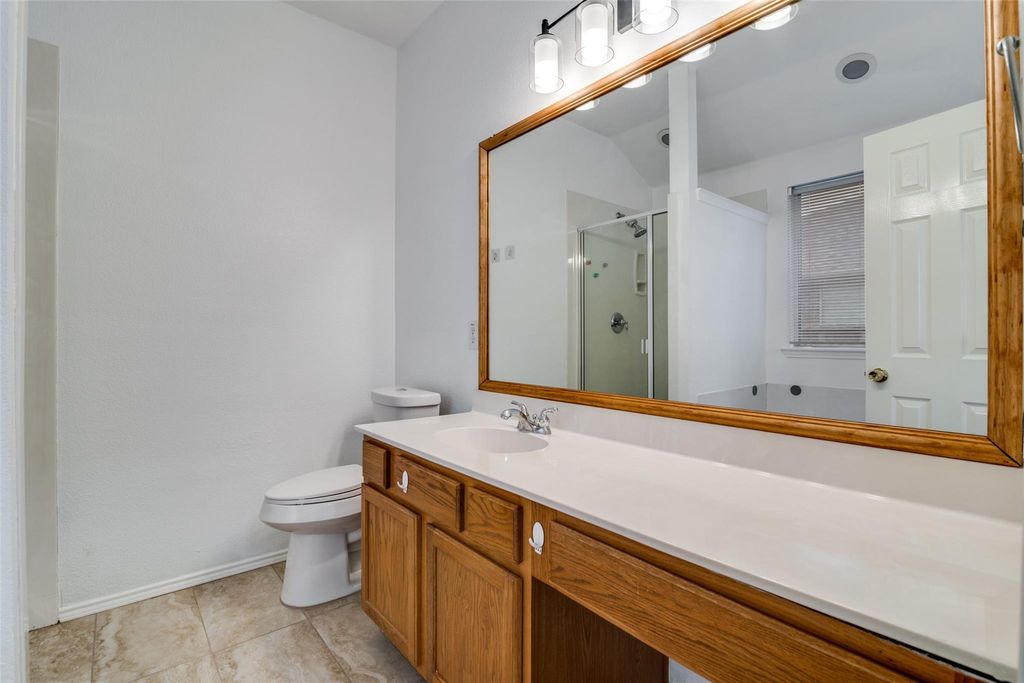 Bathroom with a stall shower, vanity, and light tile patterned flooring