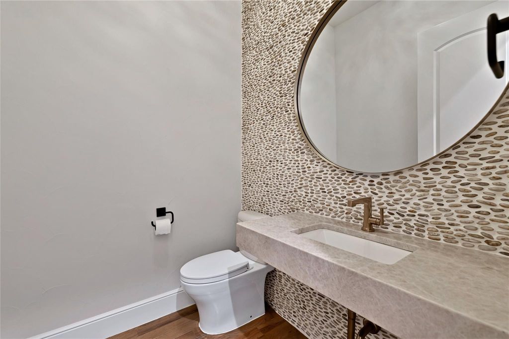 One of two 1/2 baths and this one has a custom stone wall.
