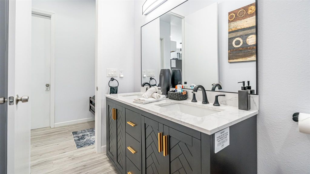 Full bathroom featuring double vanity and light wood-type flooring