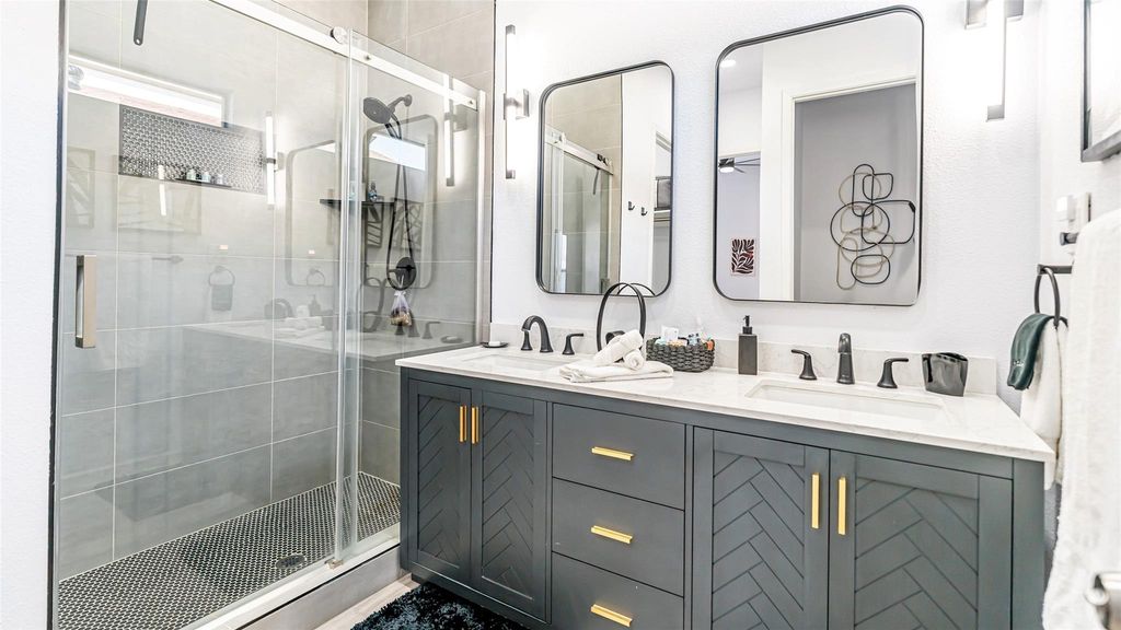 Full bathroom featuring a shower stall and double vanity