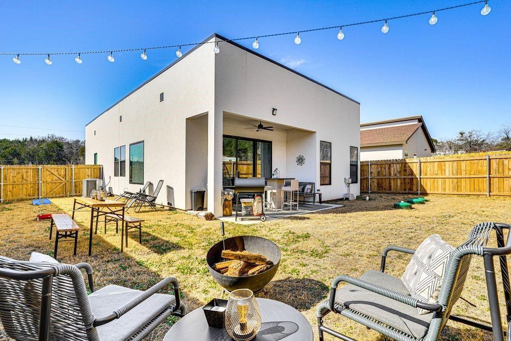 Back of property featuring a patio, ceiling fan, a fenced backyard, and stucco siding