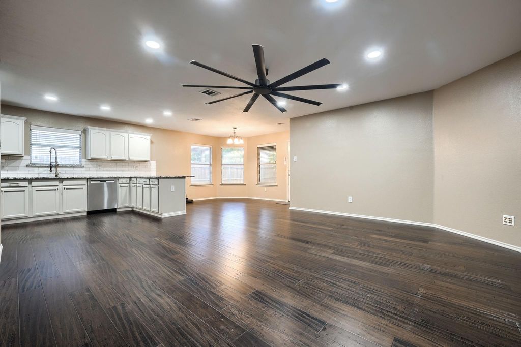 Unfurnished living room with dark wood-style floors, recessed lighting, and a ceiling fan
