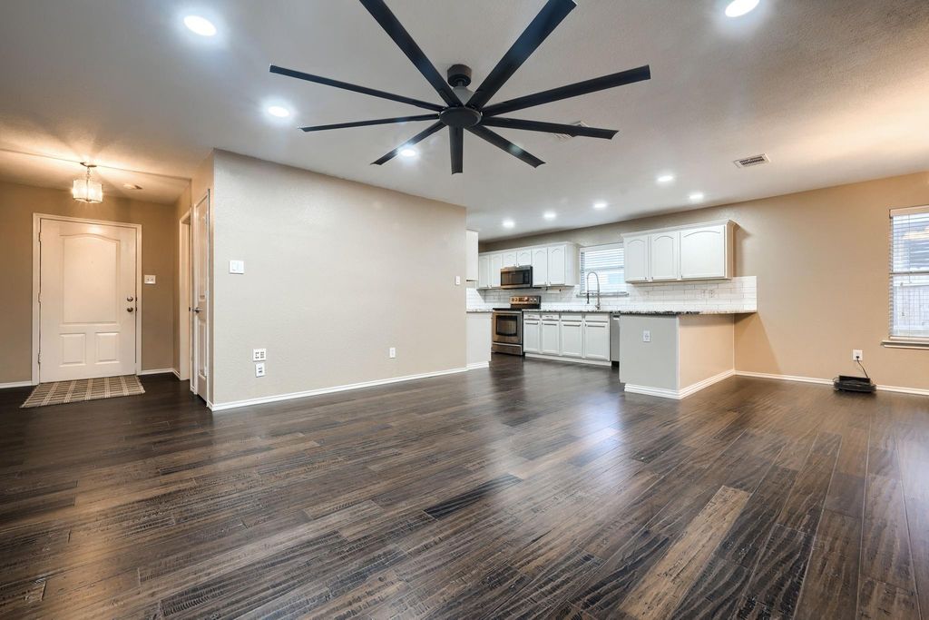 Unfurnished living room with dark wood-style flooring and recessed lighting