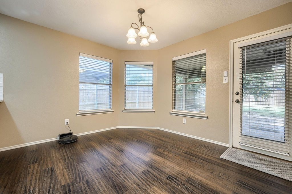 Unfurnished dining area featuring a chandelier and dark wood-style floors