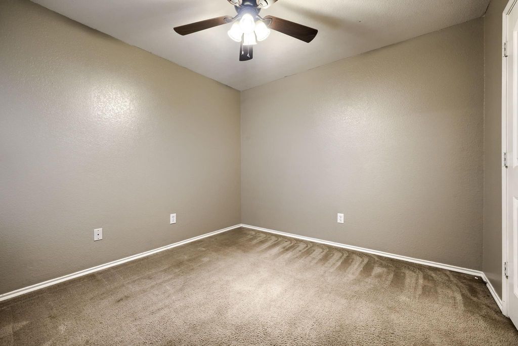 Bedroom with carpet flooring, a ceiling fan, and a textured wall