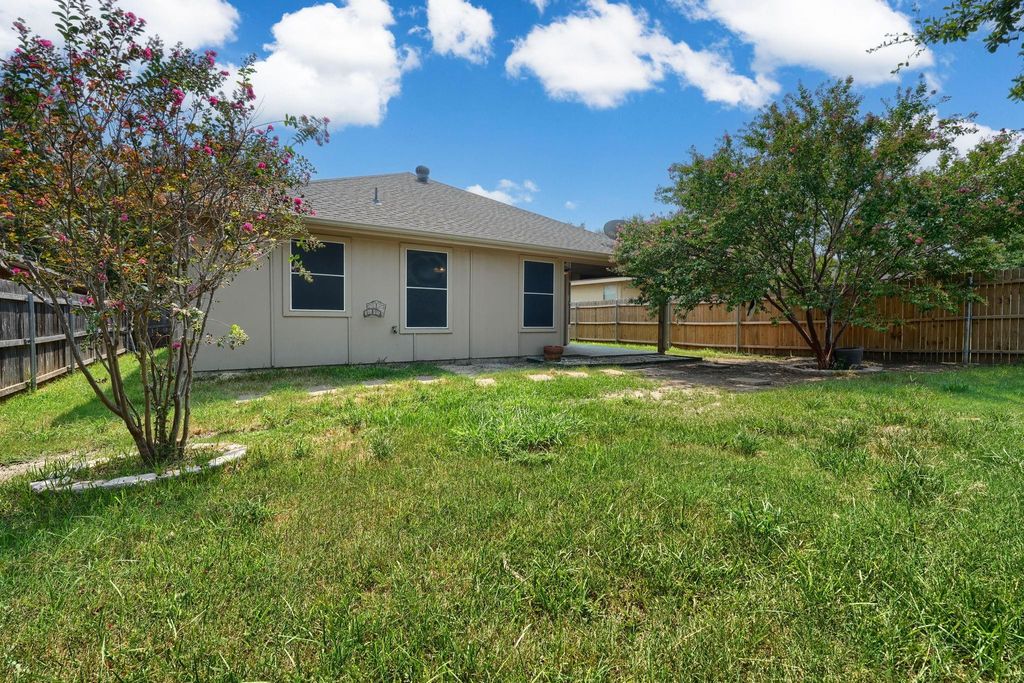 Back of house featuring a fenced backyard, a shingled roof, and a patio