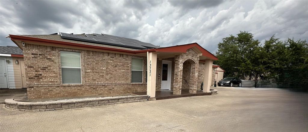 Ranch-style house with brick siding, roof mounted solar panels, and a shingled roof