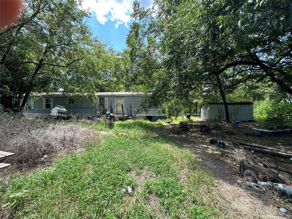 View of yard with view of scattered trees and an outdoor structure