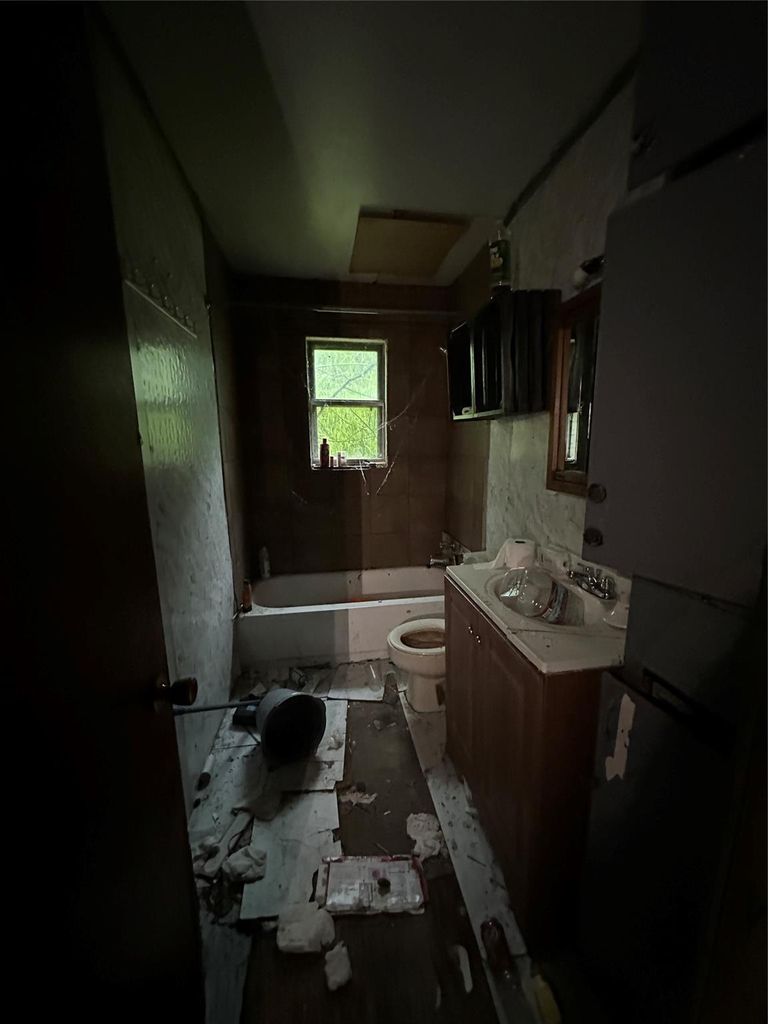Bathroom with tiled shower / bath combo and vanity