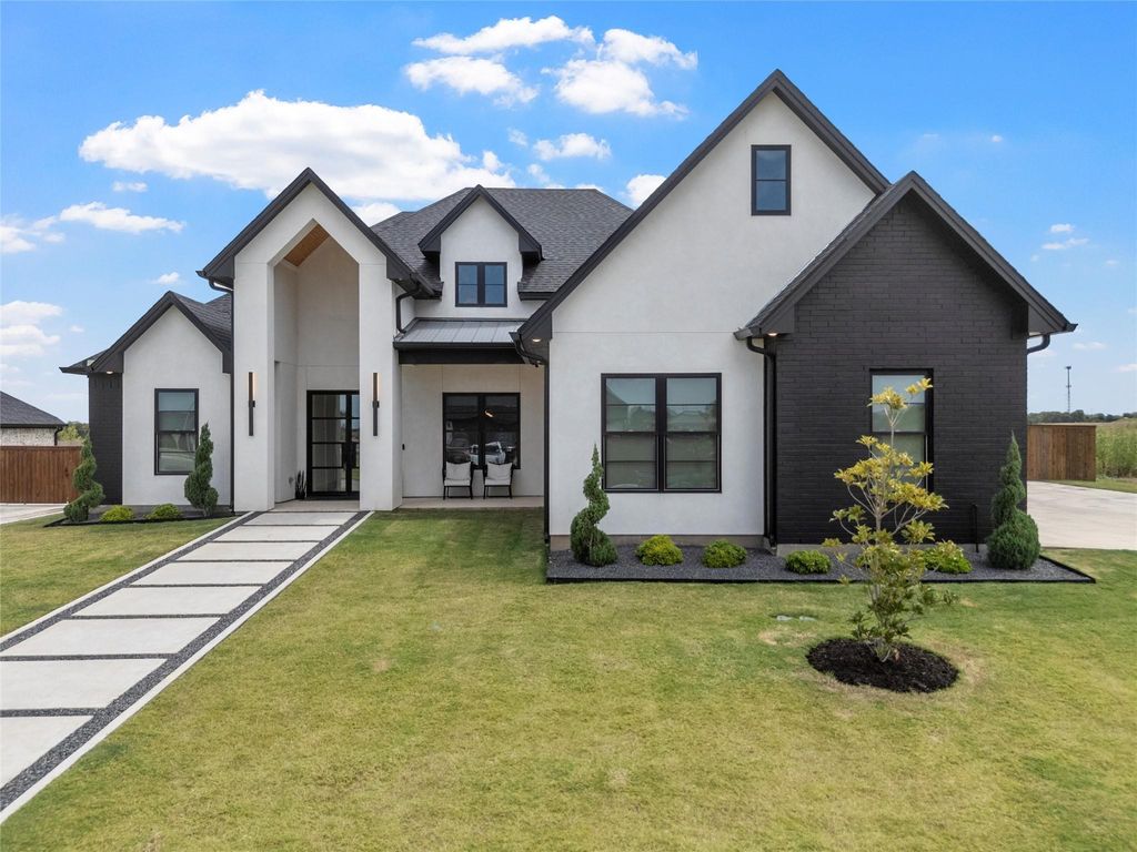 Modern farmhouse with a standing seam roof, stucco siding, a metal roof, and brick siding