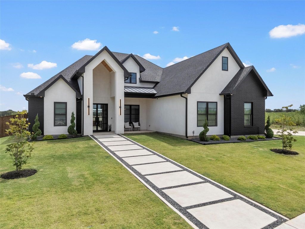 Modern inspired farmhouse featuring stucco siding, a standing seam roof, a front lawn, and a metal roof