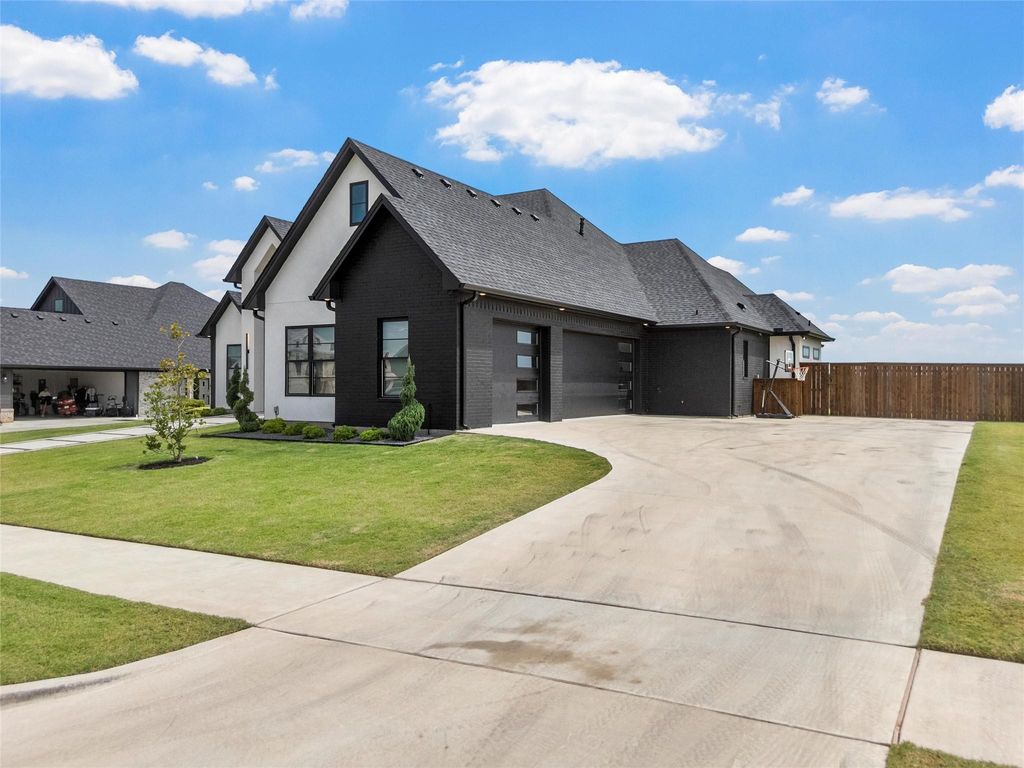 View of front of home featuring brick siding, driveway, a garage, and a shingled roof