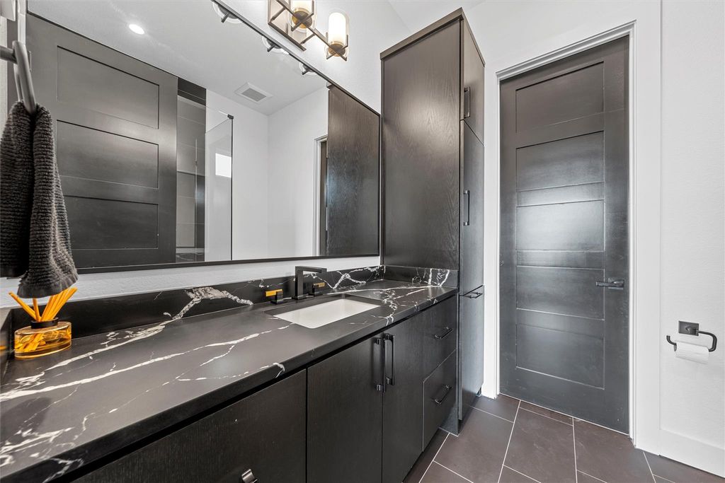 Bathroom featuring vanity and dark tile patterned floors