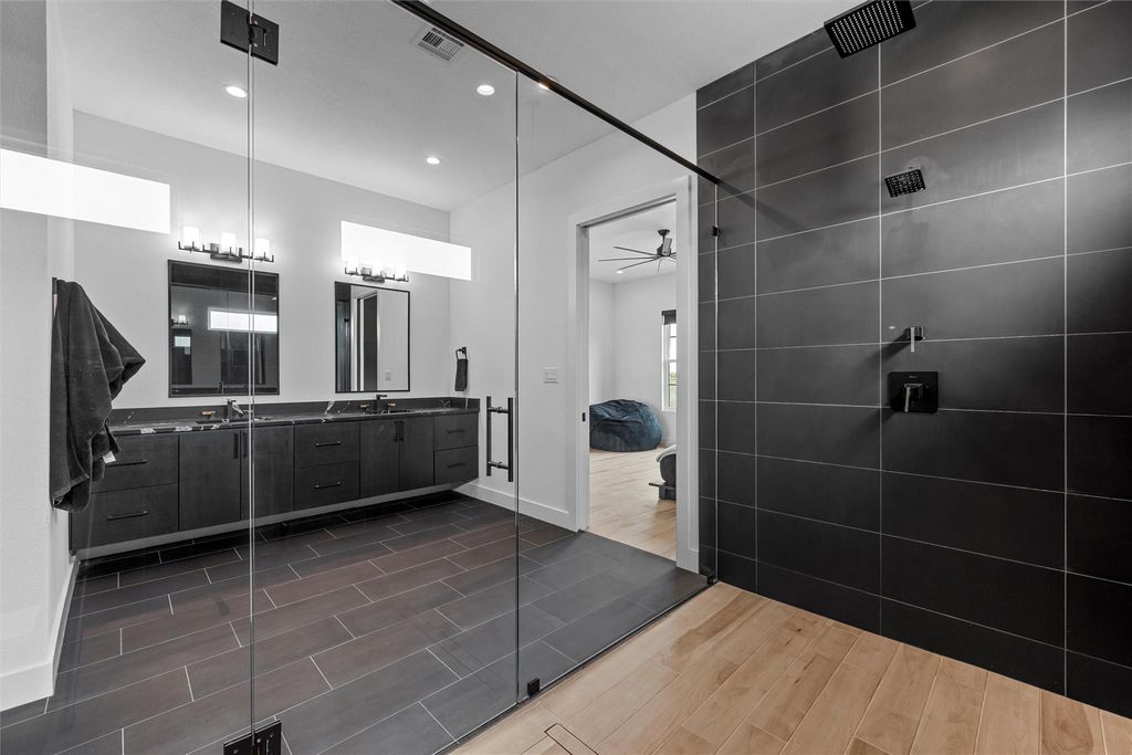 Full bathroom featuring a ceiling fan, double vanity, walk in shower, and recessed lighting