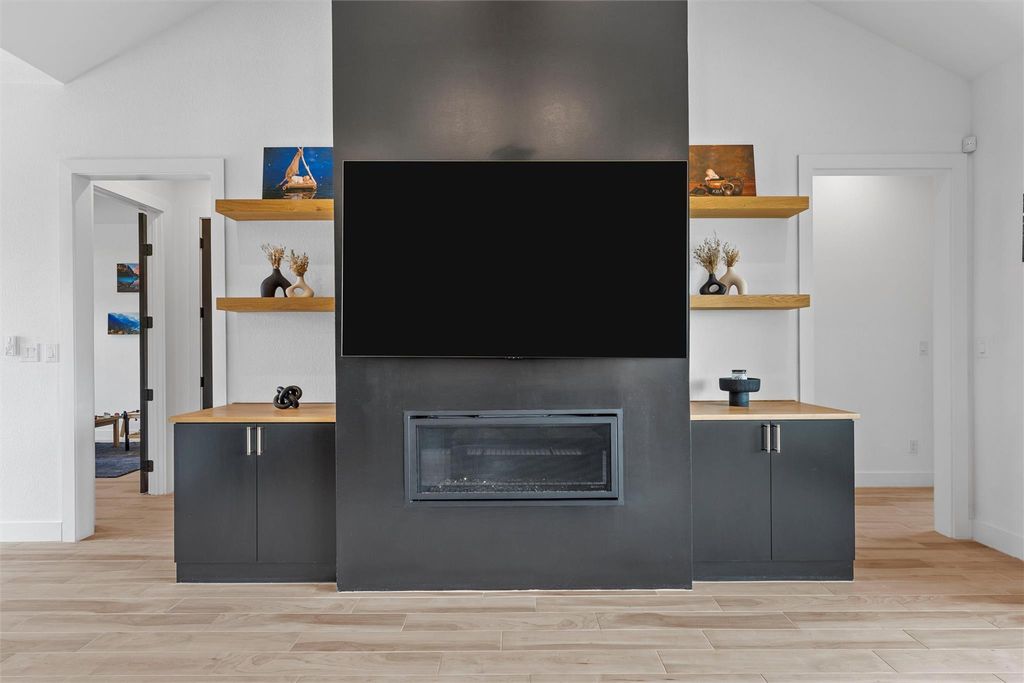 Detailed view of wood finished floors and a glass covered fireplace