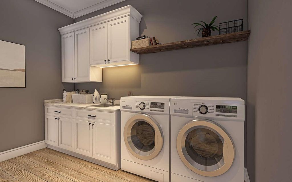Washroom featuring washer and dryer, light wood-style floors, ornamental molding, and cabinet space