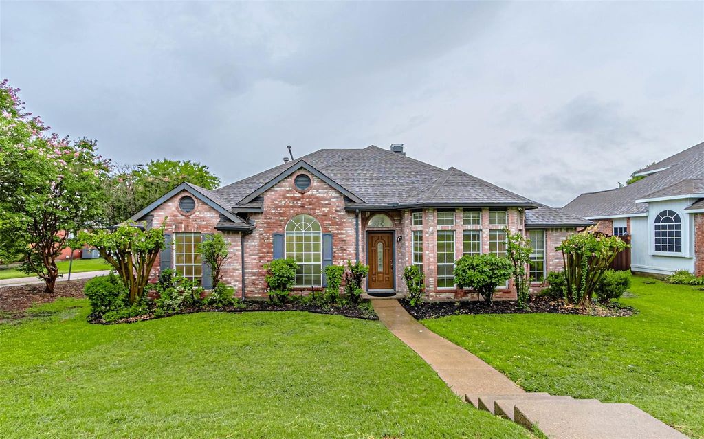 View of front of house featuring a front yard, brick siding, and a shingled roof