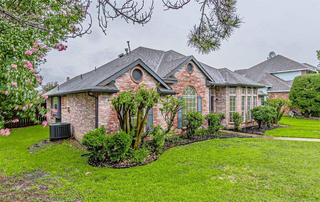 View of front of house featuring a front yard, brick siding, and roof with shingles