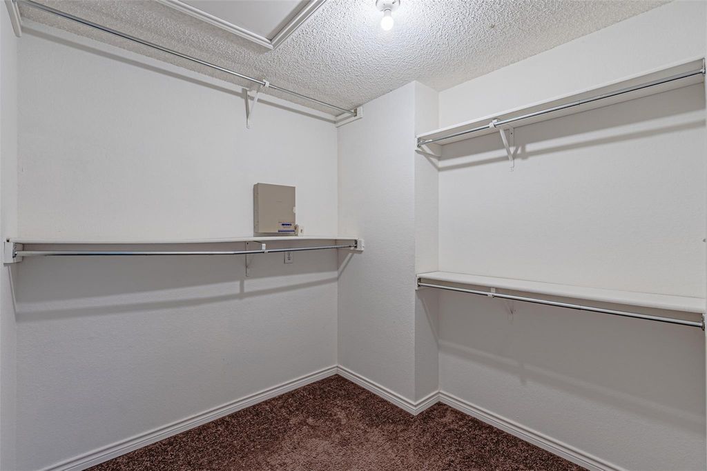 Walk in closet with dark carpet