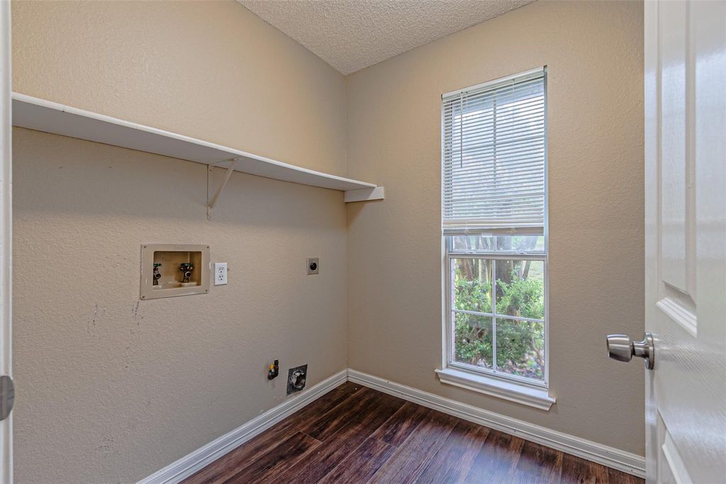 Laundry room featuring a textured wall, dark wood-style flooring, washer hookup, hookup for a gas dryer, and a textured ceiling