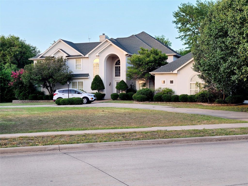 View of front of property with stucco siding, a front yard, and a chimney