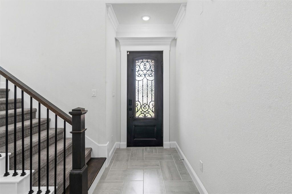 Entrance foyer featuring stairs and crown molding