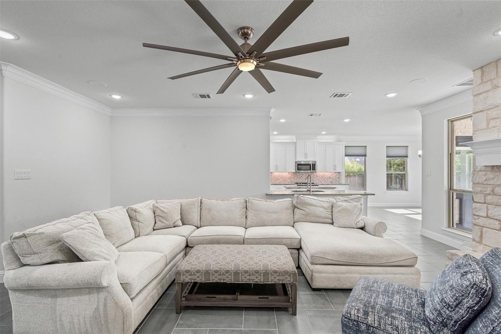 Living room with ornamental molding, recessed lighting, a fireplace, a ceiling fan, and light tile patterned flooring