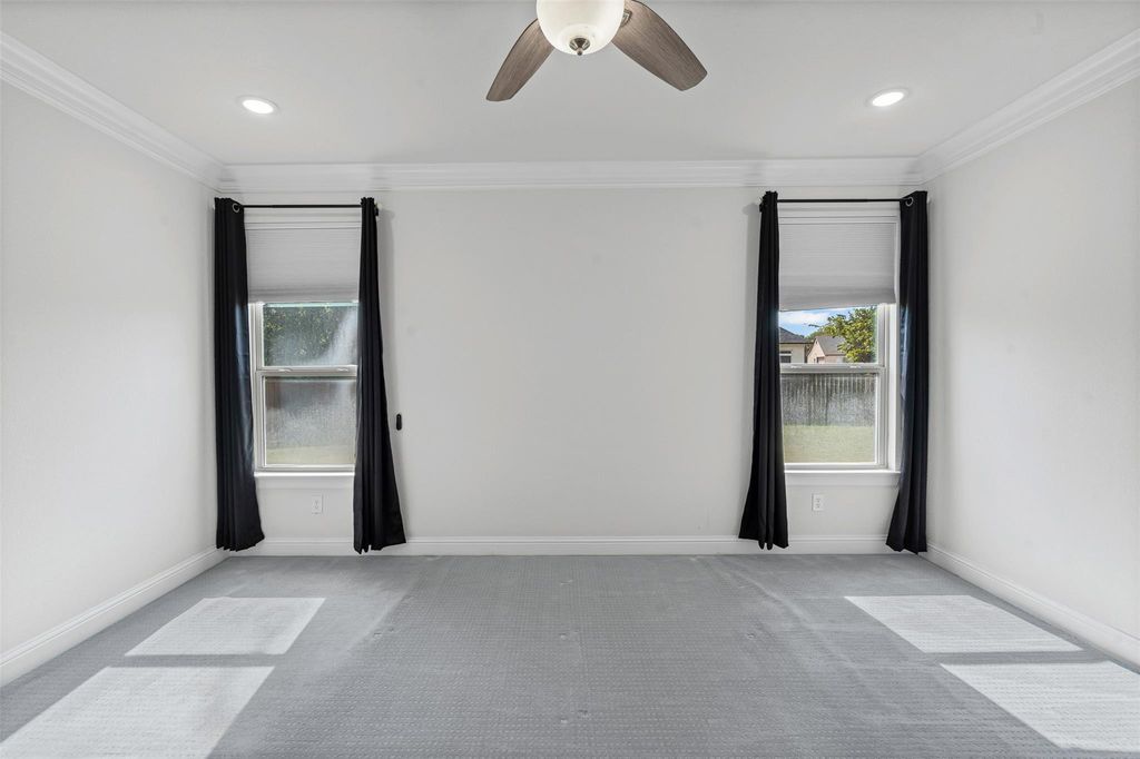 Empty room featuring ornamental molding, light colored carpet, ceiling fan, and recessed lighting