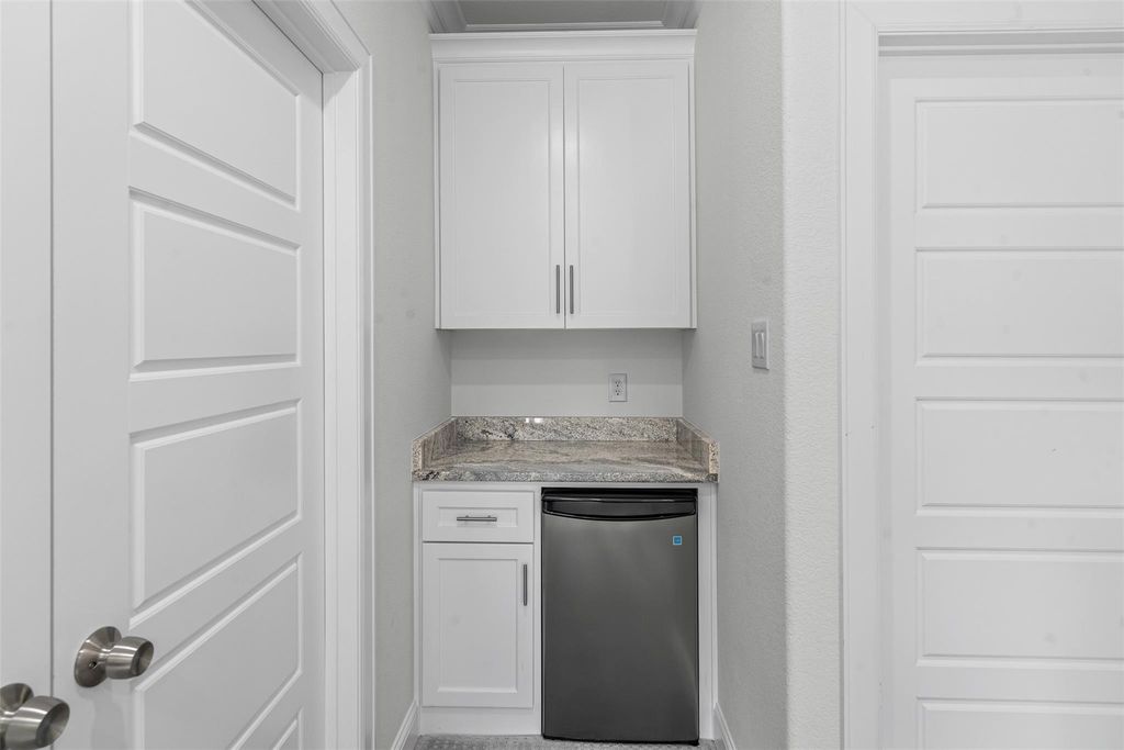 Kitchen with white cabinets and stainless steel fridge