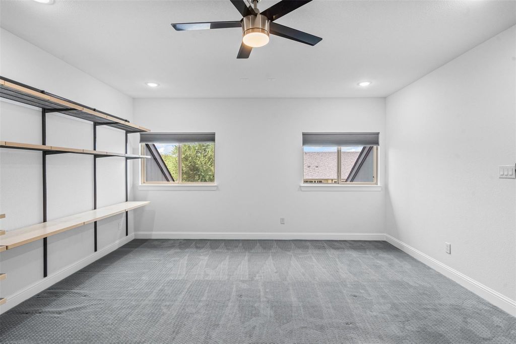 Empty room with light carpet and recessed lighting