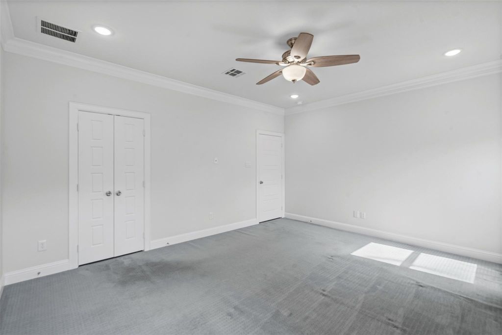 Empty room with crown molding, carpet floors, recessed lighting, and a ceiling fan