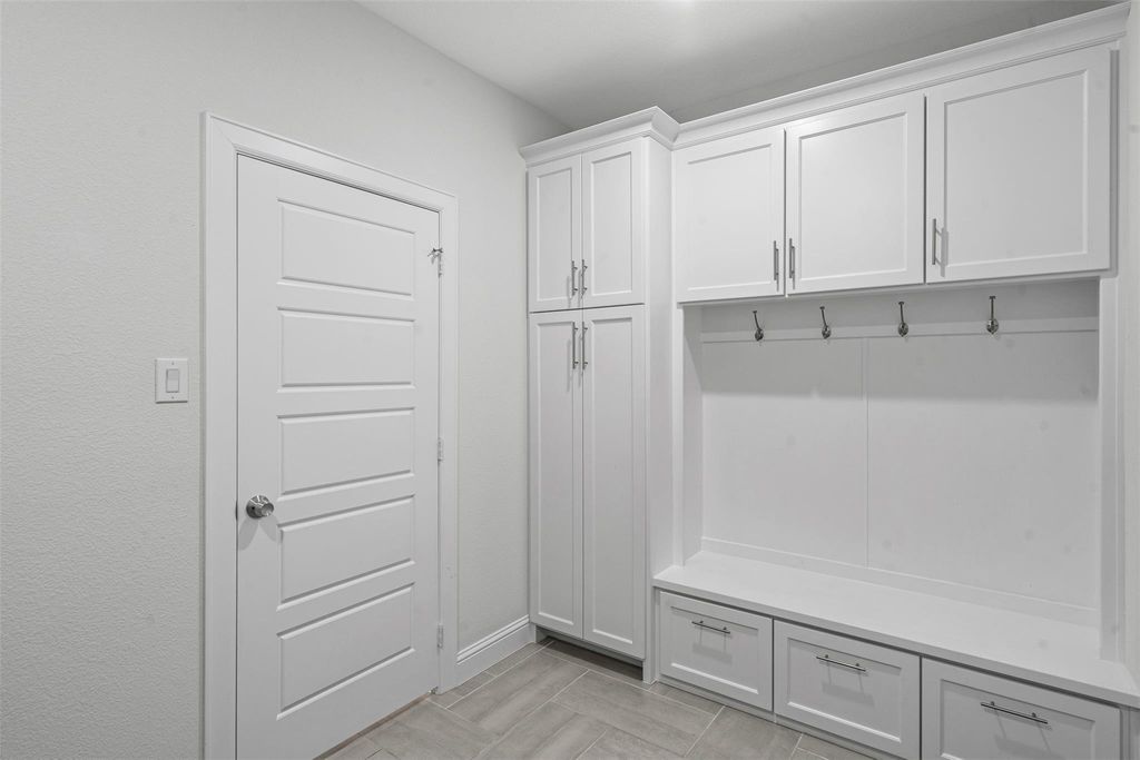 Kitchen with open floor plan, crown molding, backsplash, appliances with stainless steel finishes, and light stone counters