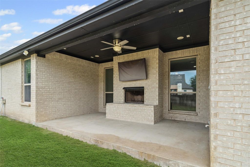 View of patio / terrace featuring a ceiling fan and an outdoor brick fireplace