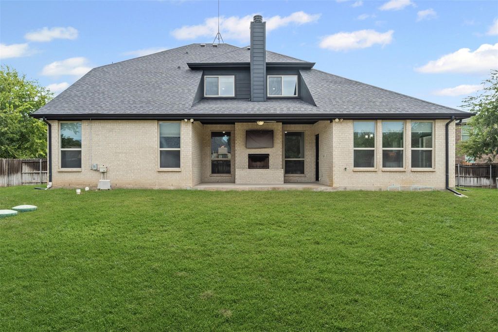 Rear view of property with a fenced backyard, a patio, brick siding, and a chimney