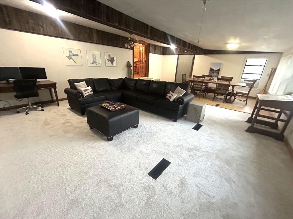 Living area featuring carpet flooring, an office area, and beam ceiling